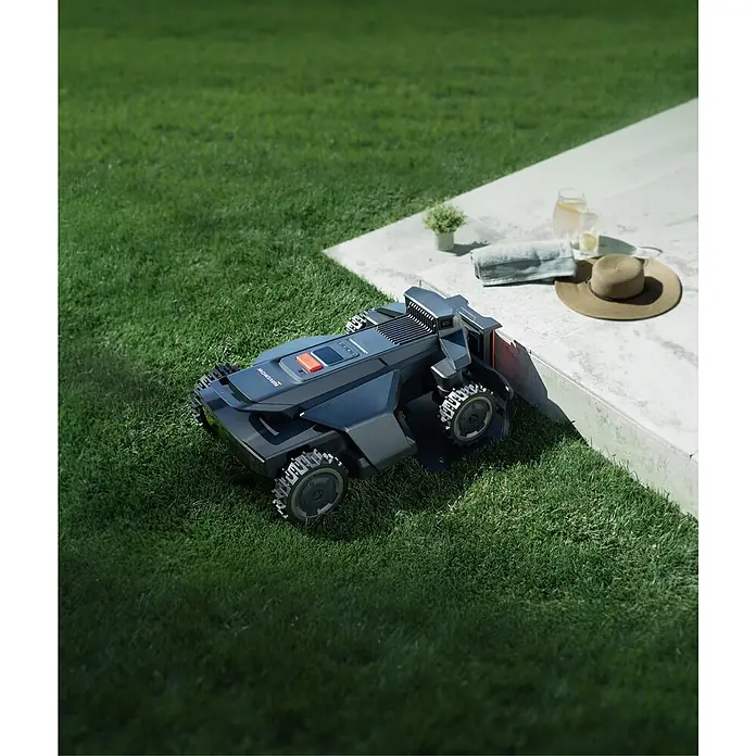 Segway Mähroboter Navimow X450 - 5.000 m², Schnittbreite: 43 cm, Satellitengestützte Navigation, RTK - Dunkelgrauer Rasenroboter mit robusten Rädern auf grünem Gras neben einer Terrasse.
