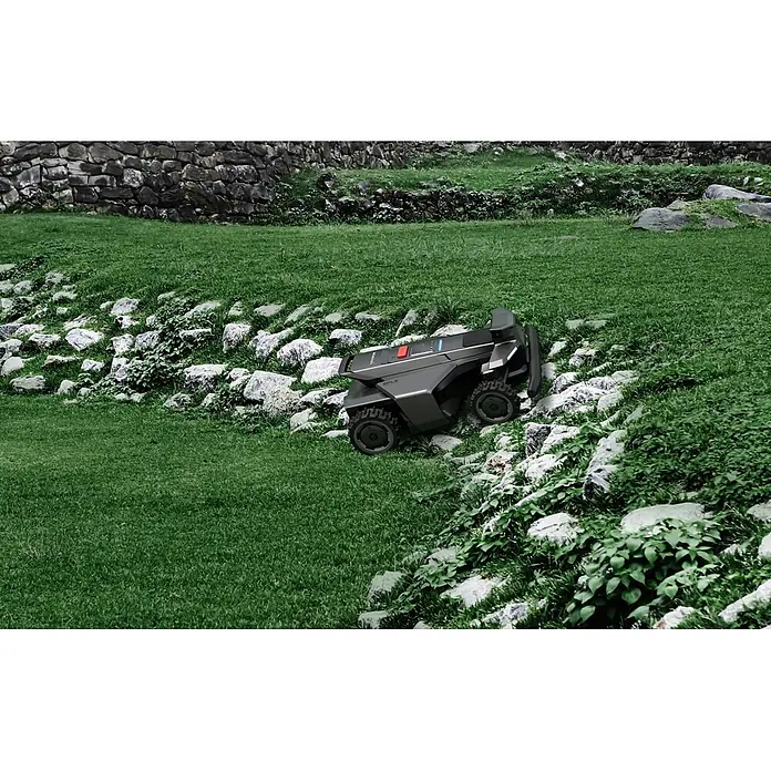 Segway Mähroboter Navimow X450 - 5.000 m², Schnittbreite: 43 cm, Satellitengestützte Navigation, RTK - Dunkelgrauer Mähroboter mit robusten Rädern navigiert einen felsigen, grasbewachsenen Hang.