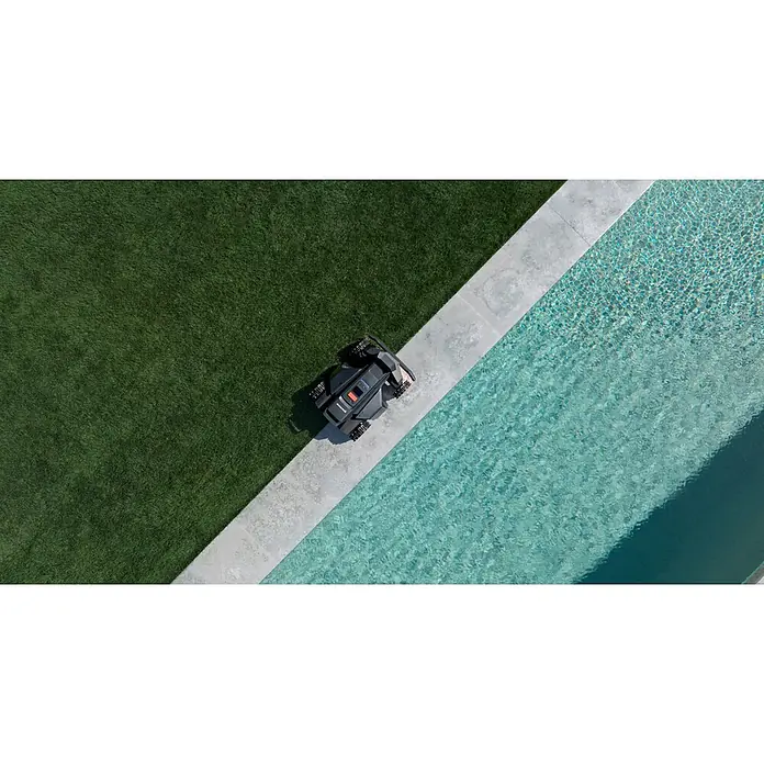 Segway Mähroboter Navimow X450 - 5.000 m², Schnittbreite: 43 cm, Satellitengestützte Navigation, RTK - Dunkelgrauer Mähroboter auf einem Betonrand zwischen grünem Rasen und einem Schwimmbad.