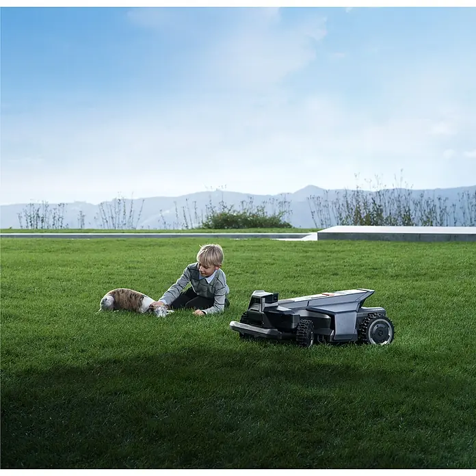 Segway Mähroboter Navimow X450 - 5.000 m², Schnittbreite: 43 cm, Satellitengestützte Navigation, RTK - Dunkelgrauer Mähroboter auf Rasen, neben einem Kind und einem Hund, betont sichere und einfache Gartenpflege.