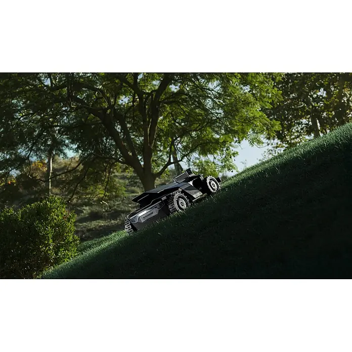 Segway Mähroboter Navimow X450 - 5.000 m², Schnittbreite: 43 cm, Satellitengestützte Navigation, RTK - Dunkelgrauer Mähroboter auf einem steilen Rasenhügel.