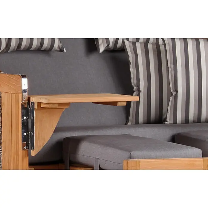 Mr. Deko Strandstuhl Strandkorb Düne Bullauge Teak PE Grey Dessin 544 - 1 Stk., Teakholz. Polyrattan, Rückenlehne verstellbar, PE Grey - Hölzerne Sofa-Armlehne mit ausgeklapptem Klapptisch, der eine praktische Ablage neben grauen Kissen und gestreiften Polstern bietet.