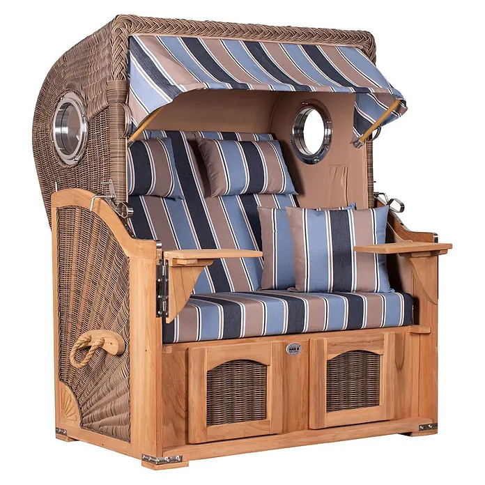 Mr. Deko Strandstuhl Strandkorb Düne Bullauge Teak PE Grey Dessin 580 - 1 Stk., Teakholz. Polyrattan, Rückenlehne verstellbar, PE Grey - Ein Strandkorb aus Weidengeflecht und Holz mit blau, braun und weiß gestreiften Polstern und Verdeck, ausgestattet mit Bullaugen und ausziehbaren Tischen.