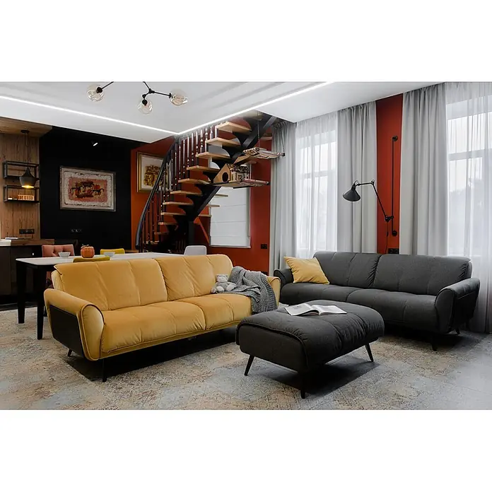 Feinsteinzeugfliese Carpet Natural - 59,2 x 59,2 cm, Vestige, Matt - Ein gemütliches, modernes Wohnzimmer mit gelbem Sofa, grauem Sofa und passendem Hocker auf gemustertem Teppich, vor roten Akzentwänden.