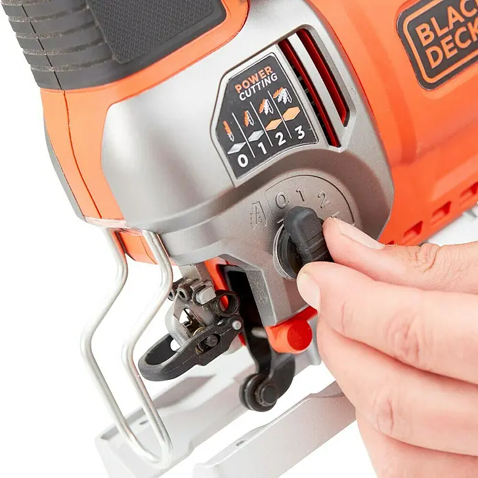 Black+Decker Sierra de calar eléctrica BES610K-QS - 1.000 /min - 3.100 /min, 90 mm - Primer plano de una sierra de calar BLACK+DECKER, con el usuario ajustando el dial de acción orbital.