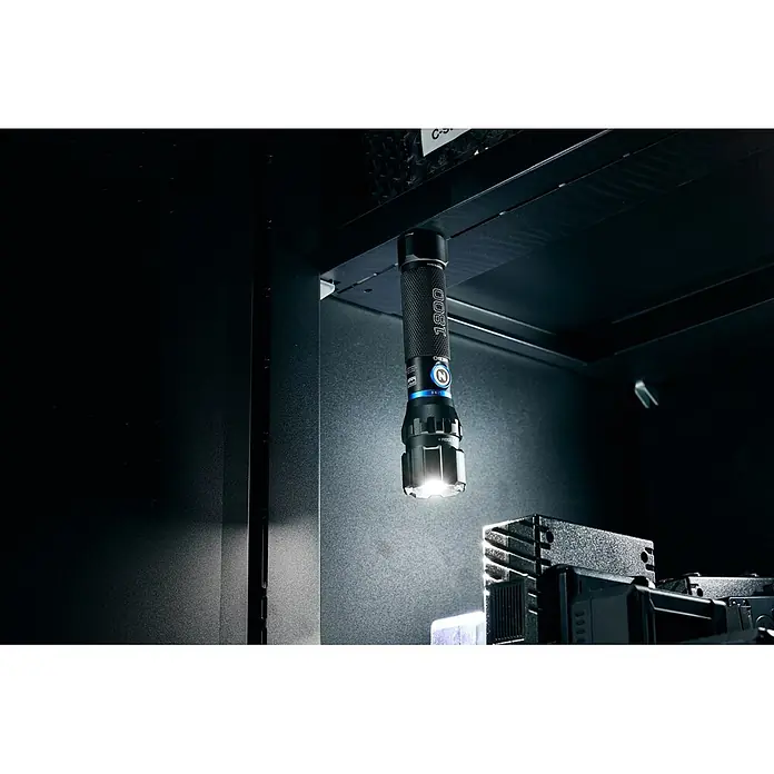 Nebo Tools Linterna Blueline 1800 - 16 x 3 x 3 cm, 180 lm - 1.800 lm, IPX7 - Linterna negra con detalles azules colgando magnéticamente de una superficie oscura, iluminando el equipo.