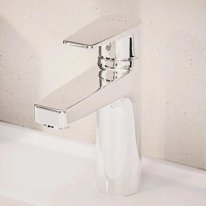 VitrA Flow Square Waschtischarmatur - Chrom, Glänzend, Höhe: 17,6 cm, Ohne Zugstange - Moderner Einhebel-Badarmatur aus Chrom auf einem weißen Waschbecken vor einer hellen, texturierten Wand.