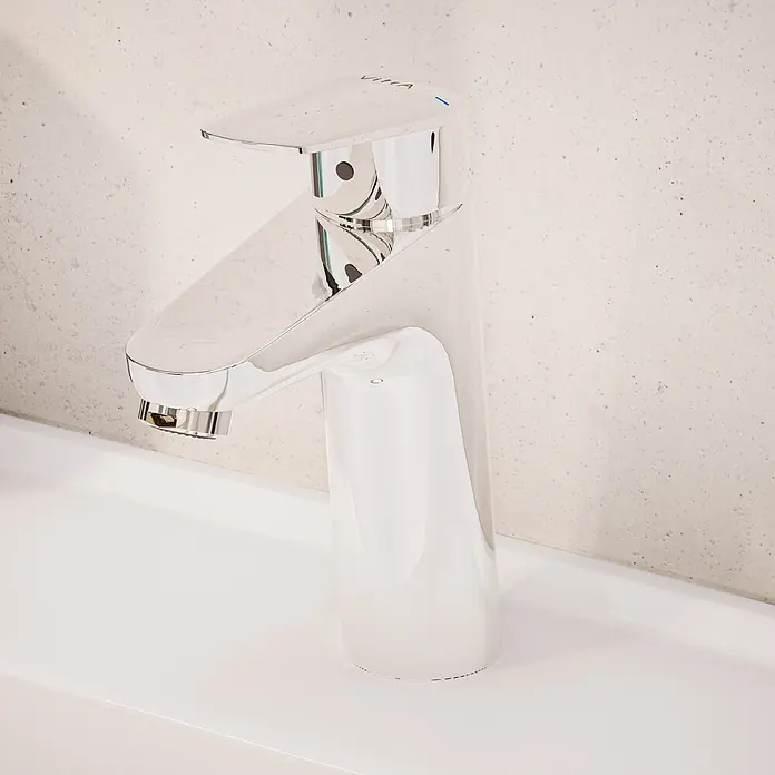 VitrA Flow Round Waschtischarmatur - Höhe: 18 cm, Ausladung Armatur: 115 mm, Chrom, Mit Zugstange - Schlanke Vitra Chrom-Mischbatterie mit blauer Anzeige, auf einem weißen Waschbecken.