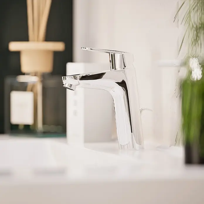 VitrA Flow Round Waschtischarmatur - Höhe: 18 cm, Ausladung Armatur: 115 mm, Chrom, Mit Zugstange - Glänzender Chrom-Wasserhahn in einem modernen Badezimmer.