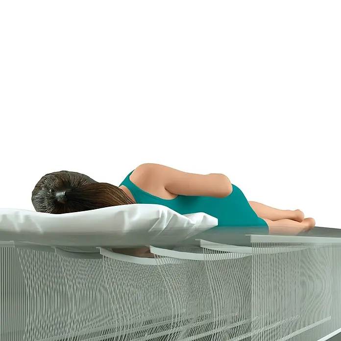 Intex Luftbett Dura-Beam Standard Pillow Rest Mid-Rise Twin - L x B x H: 191 x 99 x 30 cm, Grau/Blau - Frau liegt auf einer weißen Matratze, unterstützt von einem innovativen Bettgestell mit flexiblen vertikalen Elementen.