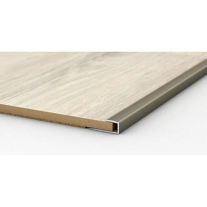 LOGOCLIC Endprofil 250 - Edelstahl matt, 0,9 m x 24 mm x 12 mm, Montageart: Kleben - Nahaufnahme eines Bodenprofils aus Aluminium, das an einem Holzbodenbelag befestigt ist. Detailaufnahme der eleganten Übergangslösung.