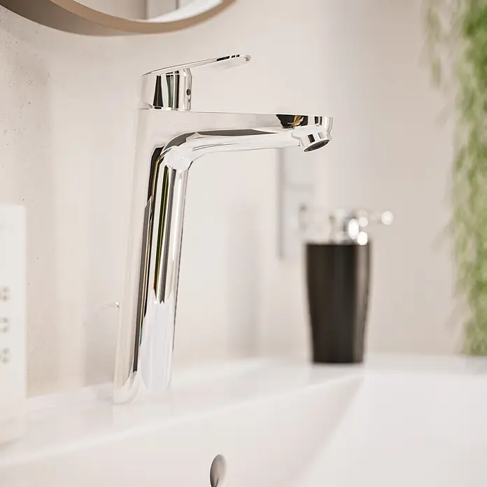 VitrA Flow Round Waschtischarmatur - Höhe: 27 cm, Ausladung Armatur: 151 mm, Chrom, Mit Zugstange - Polierter Chrom-Wasserhahn auf einem weißen Waschbecken in einem modernen Badezimmer.