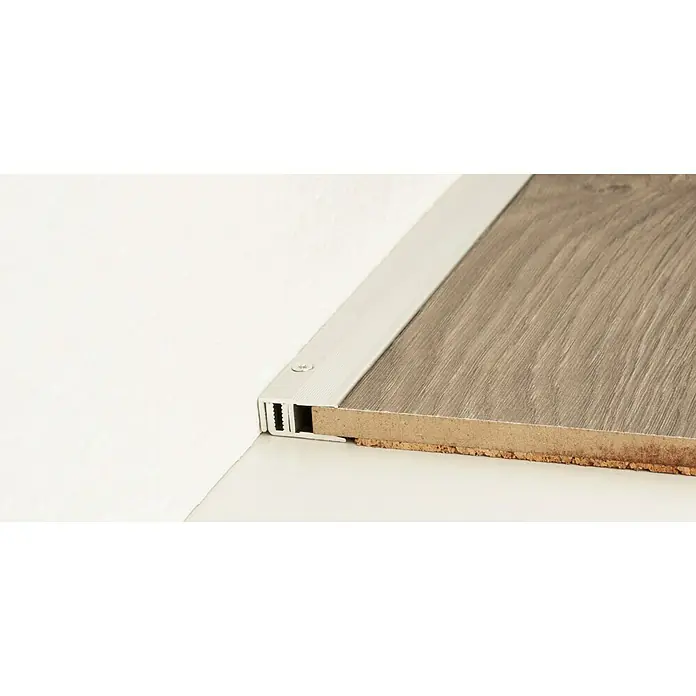 LOGOCLIC Abschlussprofil 222 - Silber, 0,9 m x 21 mm, Montageart: Schrauben - Nahaufnahme eines Bodenprofils aus Aluminium, das an einer Holzbodenplatte befestigt ist, ideal für saubere Übergänge und Abschlüsse.