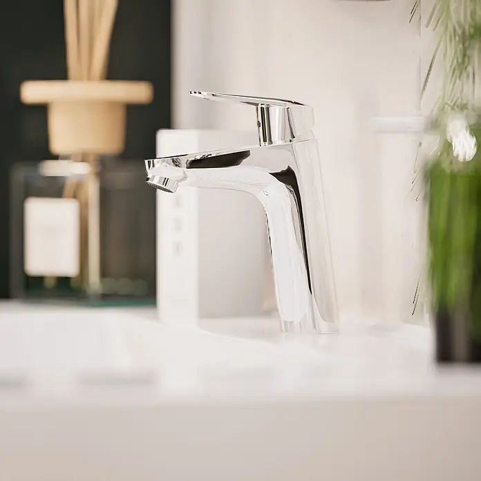 VitrA Flow Round Waschtischarmatur - Höhe: 18 cm, Ausladung Armatur: 115 mm, Chrom, Ohne Zugstange - Verchromte Armatur auf einem weißen Waschbecken in einem modernen Badezimmer.