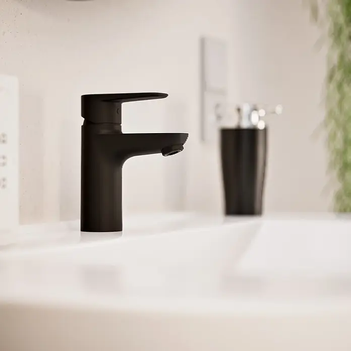 VitrA Flow Soft Waschtischarmatur - Schwarz, Höhe: 15 cm, Ohne Zugstange - Mattschwarzer Wasserhahn auf einem weißen Waschbecken.