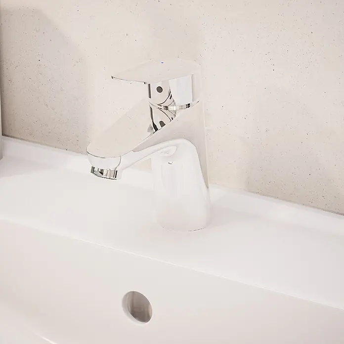 VitrA Flow Round Waschtischarmatur Eco - Höhe: 15 cm, Ausladung Armatur: 114 mm, Chrom - Glänzender Chrom-Einhebelmischer, auf einem weißen Keramikwaschbecken installiert.
