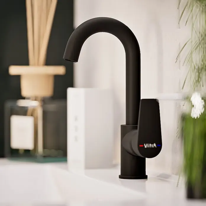 VitrA Flow Square Waschtischarmatur - Schwarz, Matt, Höhe: 28 cm - Mattschwarze Vitia Armatur auf einem weißen Waschbecken, mit unscharfem Badezimmerzubehör.