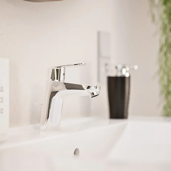 VitrA Flow Round Waschtischarmatur - Höhe: 15 cm, Ausladung Armatur: 114 mm, Chrom, Mit Zugstange - Moderner Chromwasserhahn auf einem weißen Waschbecken.