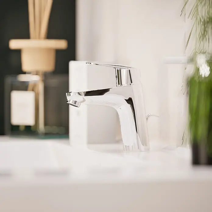 VitrA Flow Round Waschtischarmatur - Höhe: 15 cm, Ausladung Armatur: 114 mm, Chrom, Mit Zugstange - Ein moderner, glänzender Chrom-Wasserhahn auf einem weißen Waschbecken.