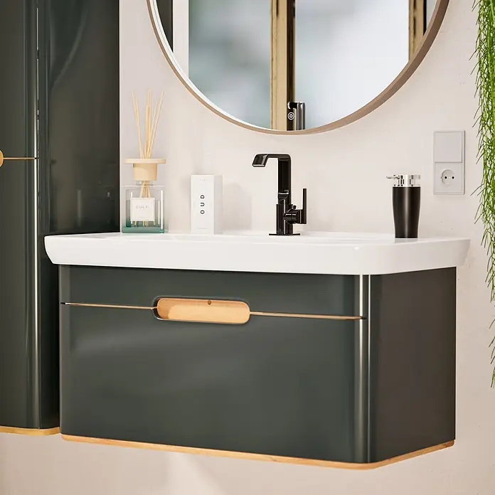 VitrA Suit Waschtischarmatur - Schwarz, Glänzend, Mit Zugstange, Höhe: 20,6 cm - Dunkelgrüner Badwaschtisch mit weißem Waschbecken, schwarzem Wasserhahn und rundem Spiegel in einem modernen Badezimmer.