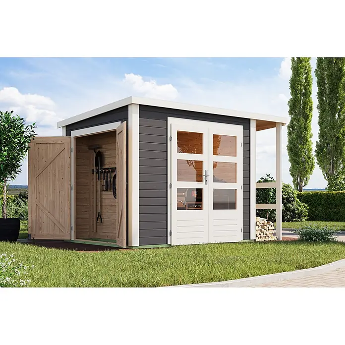 Karibu Gerätehaus Multi - Außenmaß inkl. Dachüberstand (B x T): 319 x 219 cm, Holz, Terragrau - Ein moderner dunkelgrauer Geräteschuppen mit weißem Rand und Naturholz-Türen, eine offen mit Werkzeugen, die andere mit Glaspaneelen, auf Rasen.