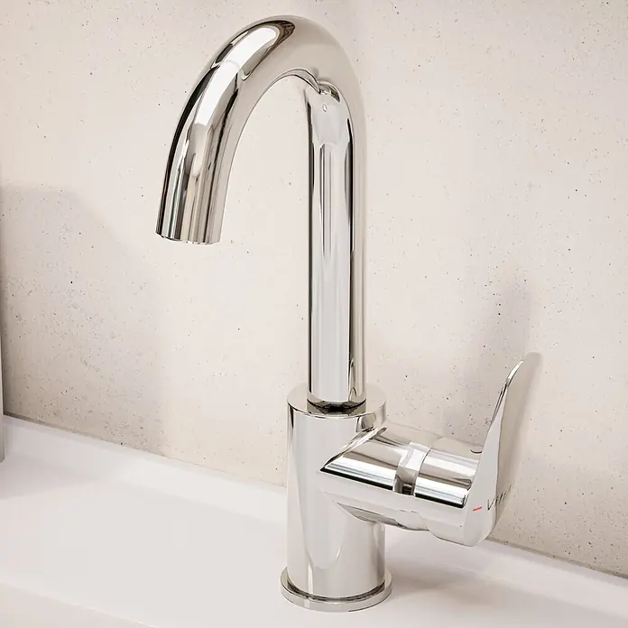 VitrA Flow Round Waschtischarmatur - Höhe: 28 cm, Ausladung Armatur: 114 mm, Chrom - Polierter Chrom-Wasserhahn mit geschwungenem Auslauf und Einhebelgriff, auf einem weißen Waschbecken vor einer strukturierten Wand.