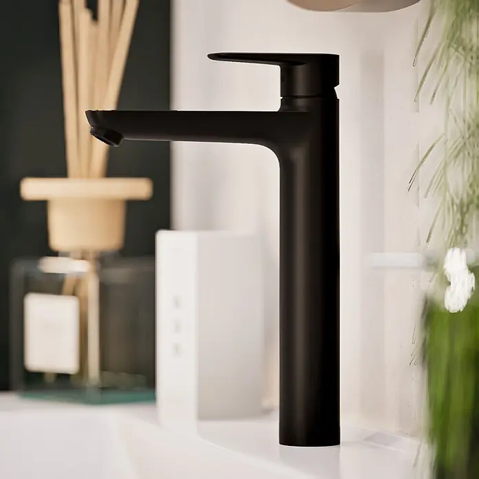 VitrA Flow Soft Waschtischarmatur - Höhe: 29,3 cm, Ohne Zugstange, Schwarz - Mattschwarzer hoher Waschtischmischer, auf einer weißen Arbeitsplatte montiert.