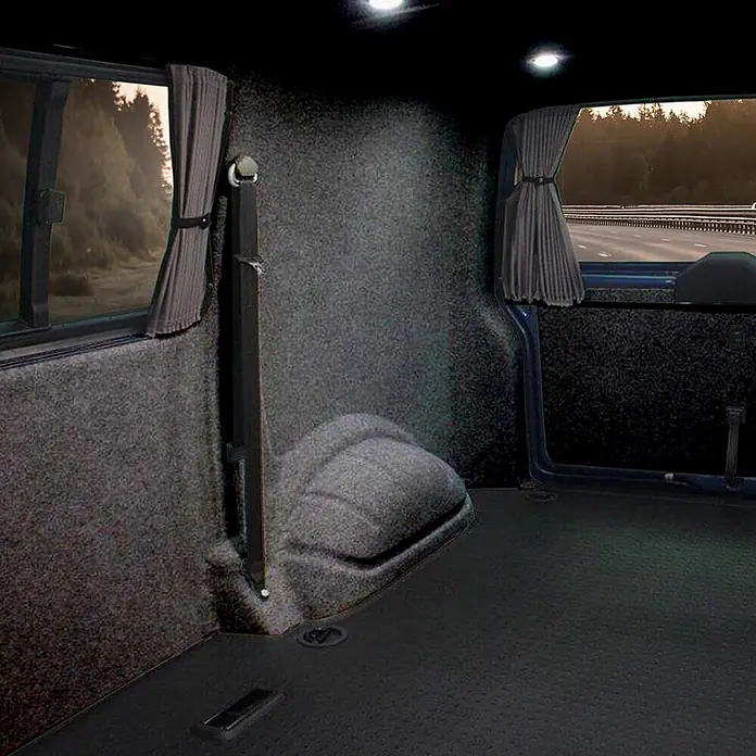 Floordirekt Nadelfilz Meterware Superflex - Heimwerkervlies - Schwarz - 200 x 100 cm - Breite: 200 cm, Filz, Schwarz - Fahrzeuginnenraum mit grauem Filzbezug an Wänden, dunklem Strukturboden, Seitenfenstern mit Vorhängen und Sicherheitsgurten.
