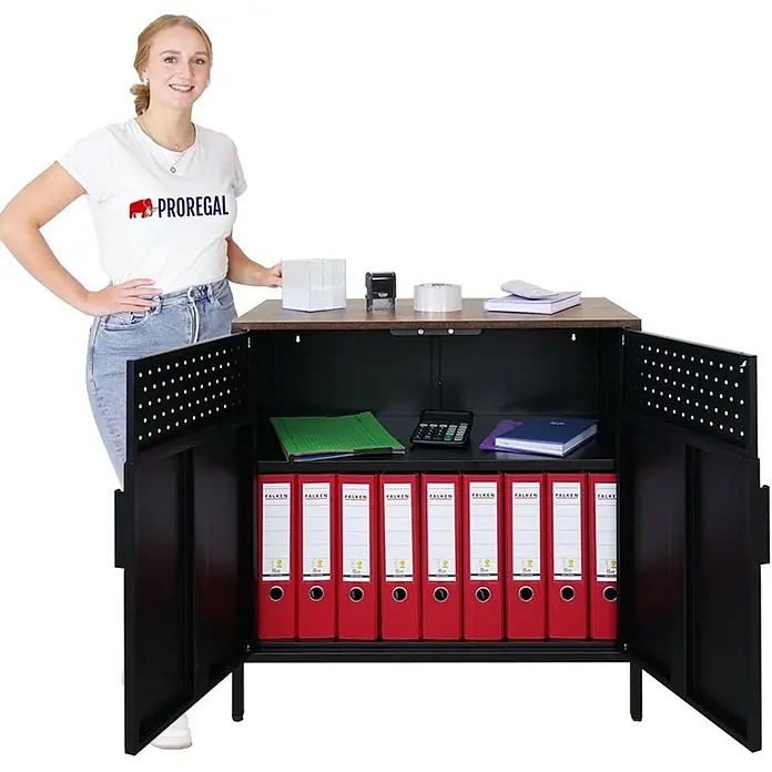 Proregal Metall-Mehrzweckschrank Mega Deal 1x LION + 1x Wandschrank ELEPHANT abschließbar - Vintagebraun/Schwarz - Schwarzer Metall-Büroschrank mit Holzplatte, offene Türen mit Ordnern. Eine Frau daneben zeigt seine kompakte Größe.