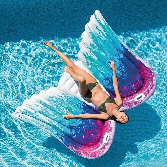 Intex Luftmatratze Angel Wings - L x B: 251 x 160 cm - Frau entspannt sich auf einer schwebenden Insel im Pool. Das aufblasbare Insel-Design ist wie Engelsflügel.