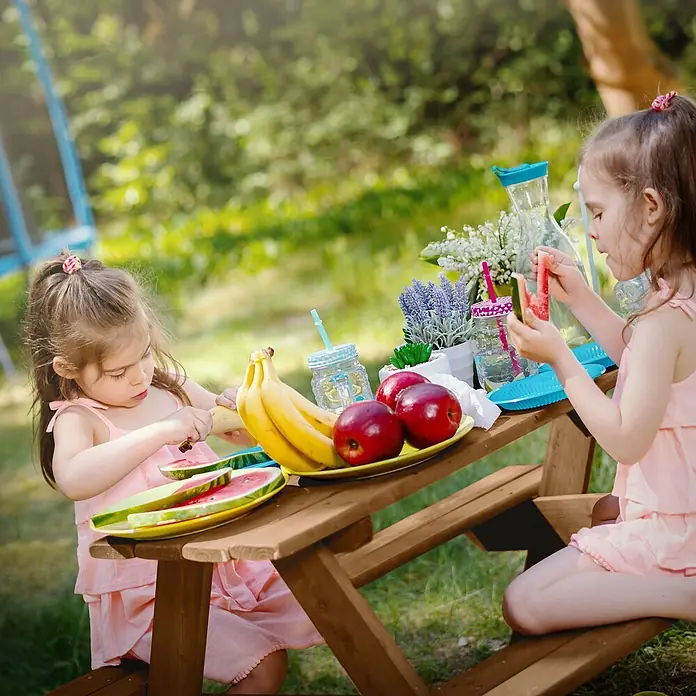 ML-Design Kinder-Picknicktisch Braun Picknicktisch Sitzgarnitur 2 Bänke mit Tisch Massivholz Outdoor - Braun, Holz - Kleiner Picknicktisch aus Holz, von zwei Mädchen für einen Snack im Freien genutzt.