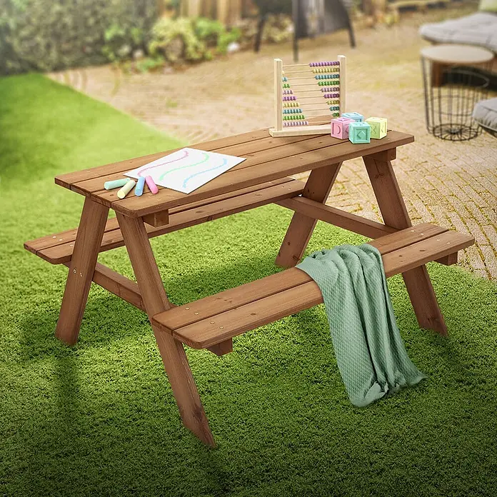 ML-Design Kinder-Picknicktisch Braun Picknicktisch Sitzgarnitur 2 Bänke mit Tisch Massivholz Outdoor - Braun, Holz - Hölzerner Kinder-Pikniktisch in Gartenumgebung, geschmückt mit bunten Spielsachen und einer grünen Decke.