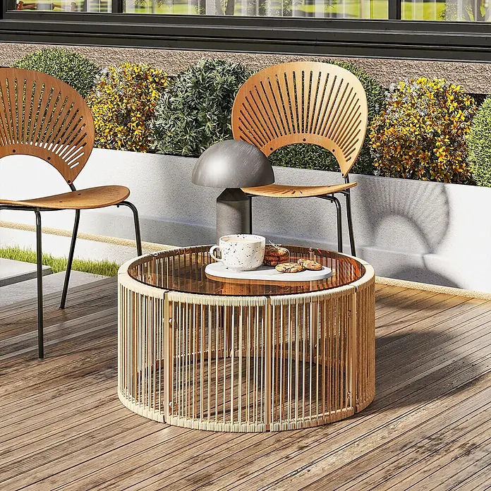 Outsunny Garten-Loungetisch - gehärtetes Glas, PE-Rattan, Braun, L x B x H: 70 x 70 x 33 cm - Ein Outdoor-Couchtisch aus Rattan mit Glasplatte, neben Holzstühlen mit schwarzen Metallbeinen, auf einer Terrasse.