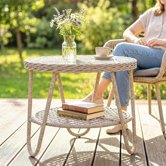 Outsunny Garten-Loungetisch - galvanisiertes Metall, PE, Gelb, L x B x H: 65 x 65 x 50 cm - Outdoor-Beistelltisch im Rattan-Stil mit Glasplatte und Ablage, darauf Blumen, Tasse und Bücher auf einer Terrasse.