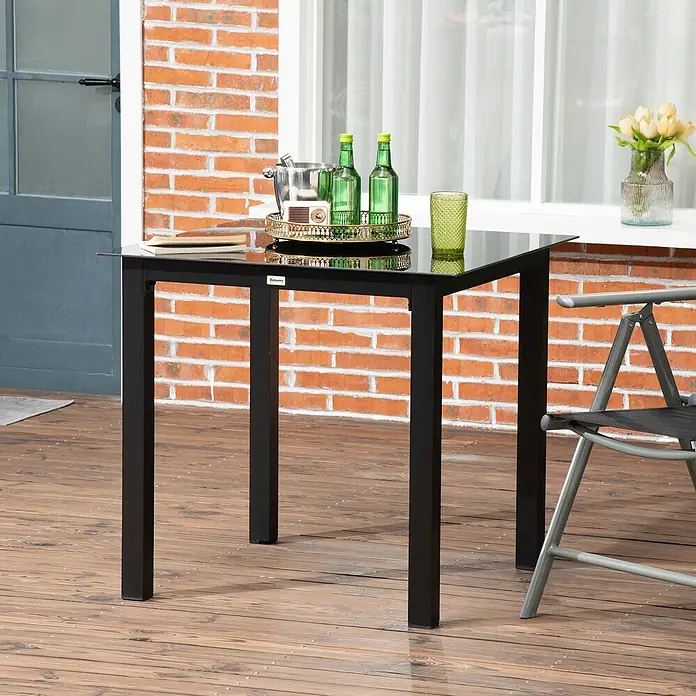 Outsunny Balkontisch mit verstellbare Fußstützen - L x B x H: 80 x 80 x 74 cm, Aluminium, Hartglas, Quadratisch, Schwarz - Schwarzer Outdoor-Bartisch mit Glasplatte auf Holzterrasse, dekoriert mit Getränken und einem Klappstuhl.