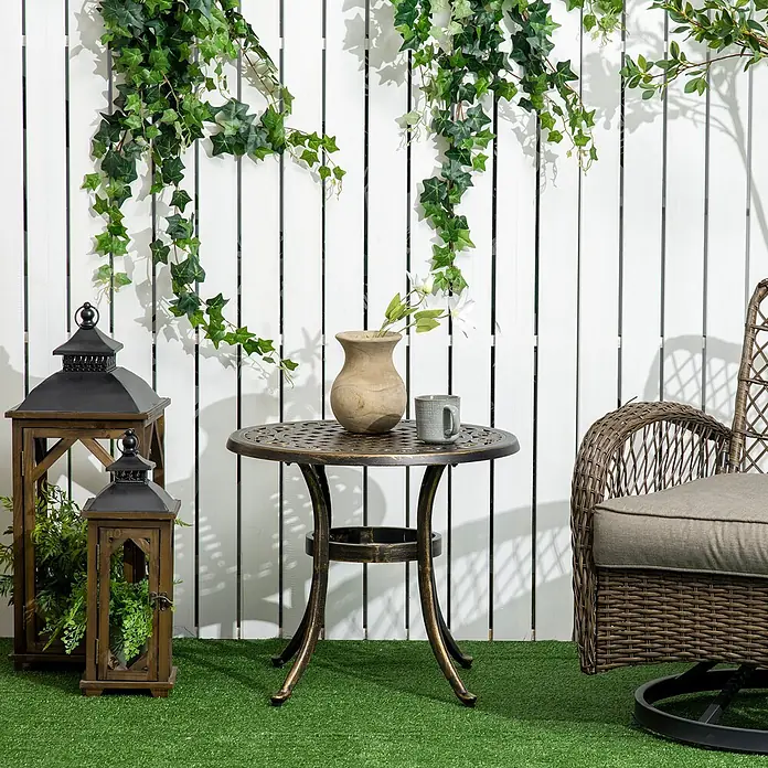 Outsunny Garten-Beistelltisch - L x B x H: 60 x 60 x 52,5 cm, Bronze - Runder Terrassentisch aus antik-bronzenem Aluminiumguss mit verzierter Platte, darauf eine Vase und ein Becher.