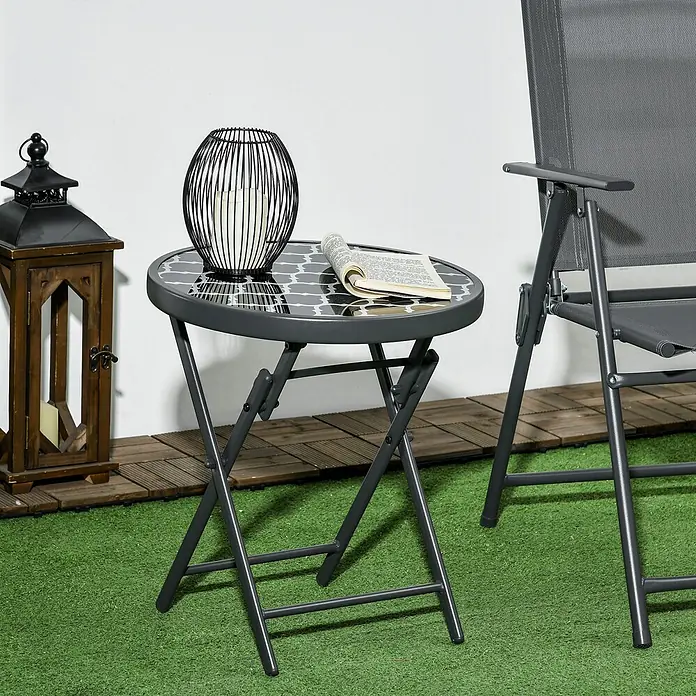 Outsunny Garten-Beistelltisch - L x B x H: 45 x 45 x 50 cm, Schwarz - Dunkelgrauer klappbarer runder Terrassentisch mit gemusterter Glasplatte und passendem Klappstuhl im Außenbereich.