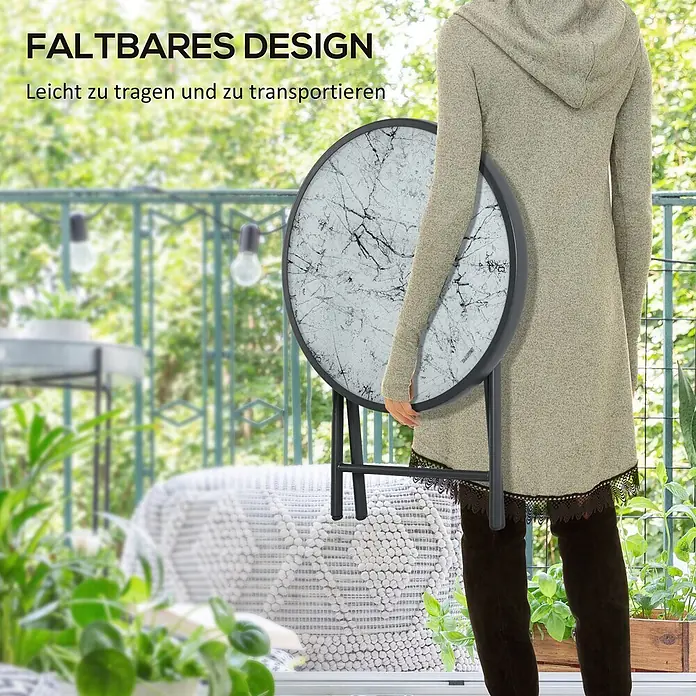Outsunny Garten-Beistelltisch - L x B x H: 45 x 45 x 50 cm, Weiß - Person trägt einen zusammengeklappten runden Tisch mit weiß-schwarzer Marmorplatte, betont seine Tragbarkeit.
