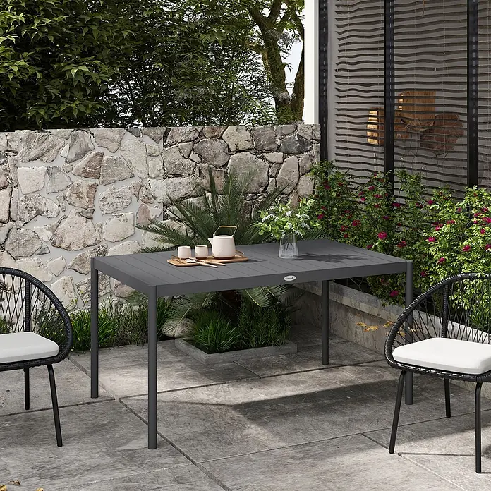 Furnicato Gartentisch - L x B x H: 145 x 90 x 74 cm, Rechteckig, Dunkelgrau - Dunkelgrauer Gartentisch und zwei schwarze Korbstühle auf einer Terrasse, mit Teekanne und Blumen geschmückt.