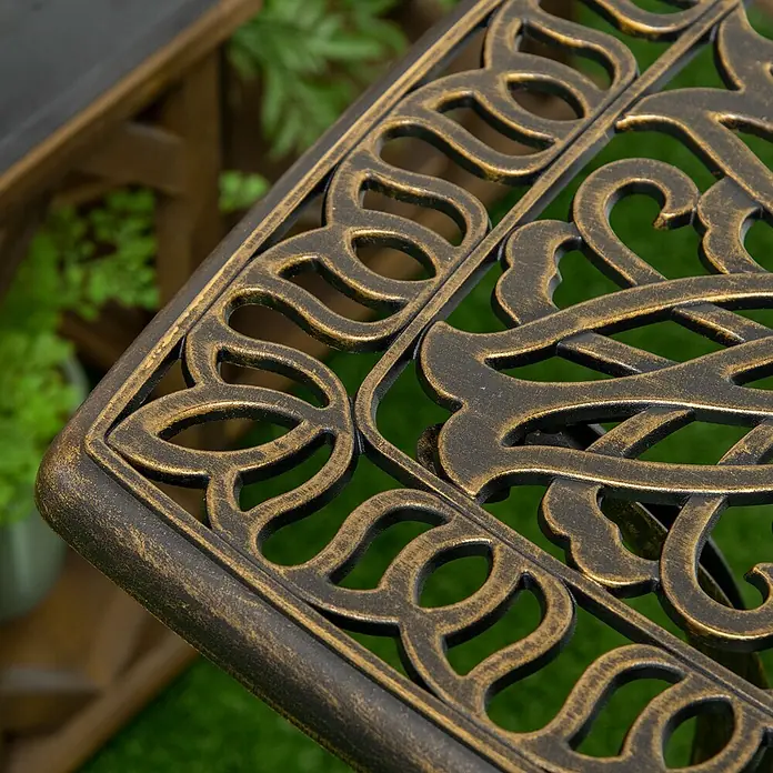 Outsunny Garten-Beistelltisch - Bronze - Nahaufnahme einer dunkelbronzenen verzierten gusseisernen Gartentischplatte.