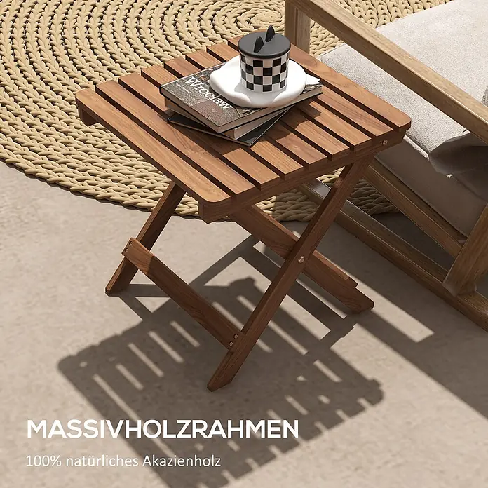 Outsunny Garten-Beistelltisch - L x B x H: 45 x 45 x 45 cm, Teak - Klappbarer Beistelltisch aus natürlichem Akazienholz mit Lattenplatte, auf dem Bücher und eine Tasse stehen, auf einer Terrasse.