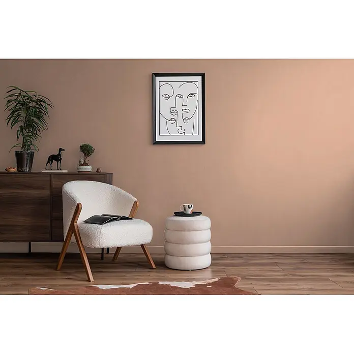 Livingwalls Wandfarbe Rosa Diverse Apricot DD126175 1l - Rosa, Matt, 1 l - Modernes Wohnzimmer mit weißem Bouclé-Sessel und hellem Stapel-Ottoman, ergänzt durch einen dunklen Holzschrank.