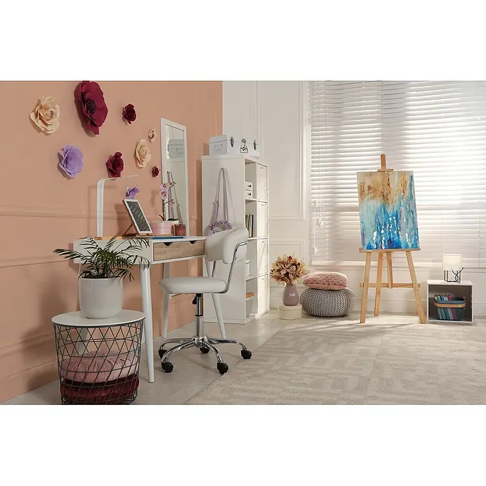 Livingwalls Wandfarbe Rosa Diverse Apricot DD126175 1l - Rosa, Matt, 1 l - Moderner weißer Schreibtisch mit Holzschublade und passendem weißen Stuhl in hellem, kreativem Arbeitsbereich mit Papierblumen und Staffelei.