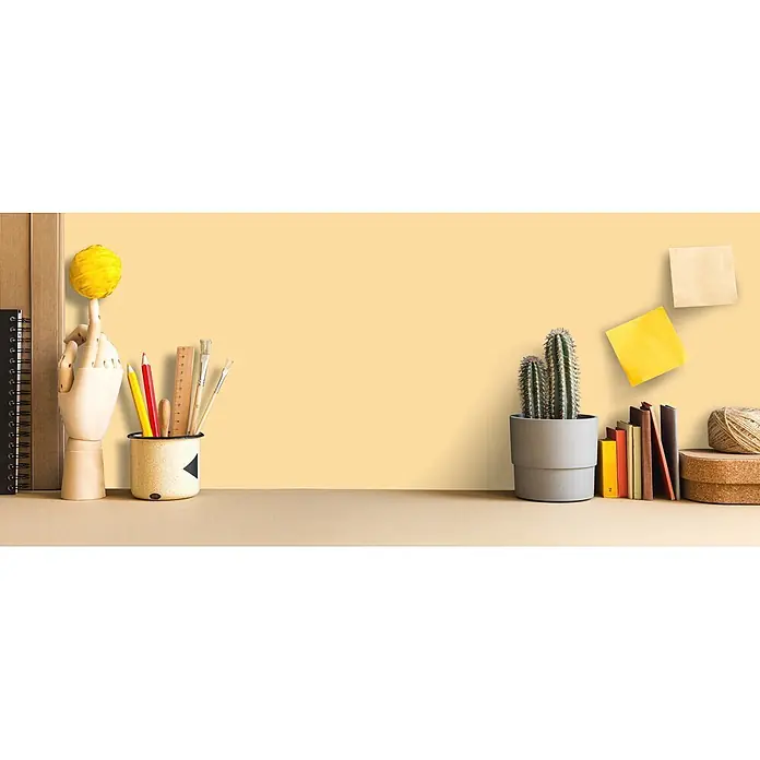 Livingwalls Wandfarbe Gelb Gentel Ginger 5004 5l - Matt, 5 l - Ein aufgeräumter Schreibtisch mit Holzhand, Kunstbedarf, Kaktus, Büchern und Notizen, der einen kreativen Arbeitsplatz schafft.