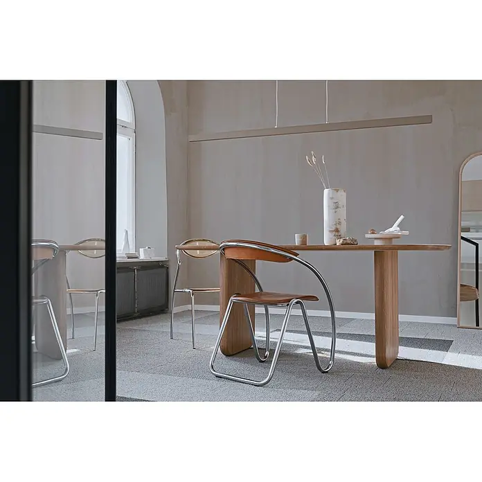 Livingwalls Wandfarbe Grau Creamy Grey DD125763 5l - Grau, Matt, 5 l - Moderner Essbereich mit hellem Holztisch und Stühlen mit Chromgestell, braunen Ledersitzen und klaren Rücklehnen in einem hellen Raum.
