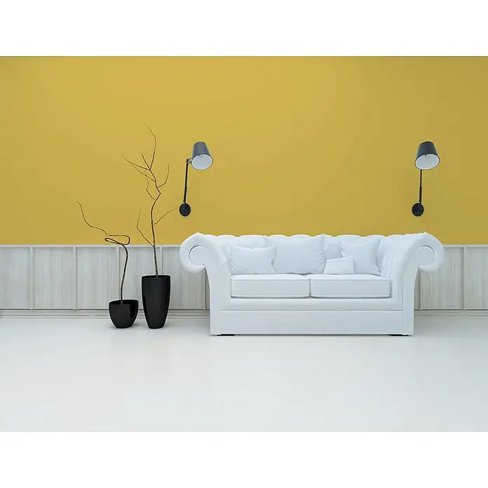 Livingwalls Wandfarbe Gelb Sunny Yellow DD126102 5l - Gelb, Matt, 5 l - Elegantes weißes getuftetes Sofa mit weißen Kissen in einem modernen Raum mit gelber Wand.