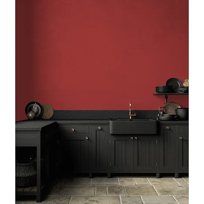 Livingwalls Wandfarbe Rot Varied Red DD125821 1l - Rot, Matt, 1 l - Schwarze Küchenschränke mit schwarzem Spülbecken und Messingarmatur vor einer leuchtend roten Wand und Steinboden.