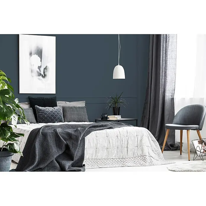 Livingwalls Wandfarbe Blau Bluish Petrol DD125914 1l - Blau, Matt, 1 l - Ein Bett mit einem weißen strukturierten Bettbezug, einer dunkelgrauen Waffelpikee-Decke und grauen Kissen in einem modernen Schlafzimmer.