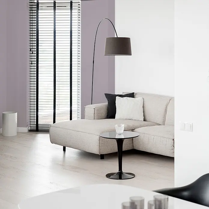 Livingwalls Wandfarbe Violett Simple Mauve DD125774 2,5l - Violett, Matt, 2,5 l - Modernes beiges Ecksofa mit dunkelgrauer Bogenlampe und schwarzem Beistelltisch in hellem Wohnzimmer.