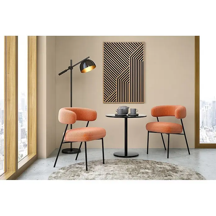 Tadessi Wandfarbe Cremebeige - Beige, Matt, 1 l - Zwei orange gepolsterte Stühle mit schwarzen Beinen umrahmen einen schwarzen runden Tisch, der einen gemütlichen Sitzbereich am Fenster bildet.